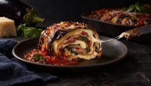 Auberginerol met provola en pancetta in Campanië, met tomatensaus, een aubergine, Parmigiano en basilicum ernaast