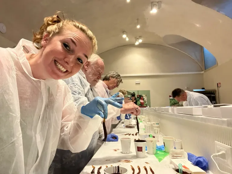 Deelnemers maken chocolade in beschermende kleding.