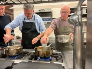 Drie mannen koken samen in een professionele keuken.