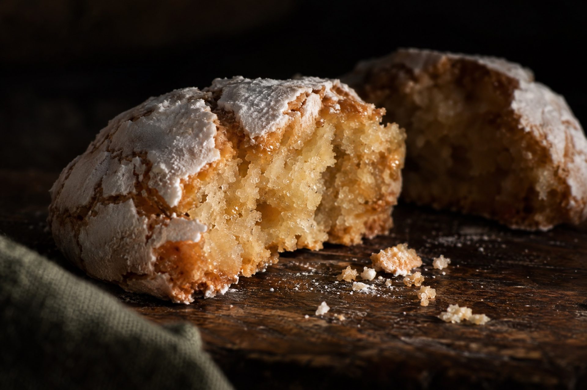 Detail van Italiaanse koekjes, amaretti morbidi: gebarsten korst van poedersuiker en een vochtig amandelhart