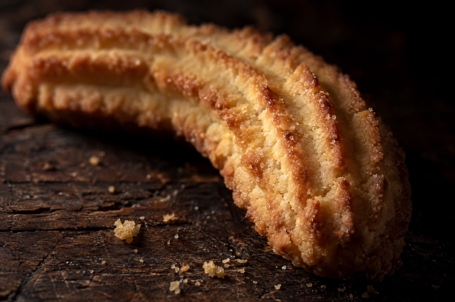 Closeup van gebakken krumiri met diepe ribbels van de sterspuitmond en een goudbruine, zanderige korst
