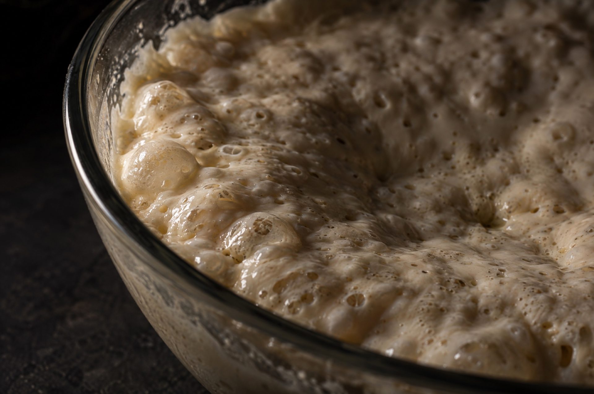 Close-up van de rijpe poolish in een glazen kom, met grote bellen aan het oppervlak en een gewelfde rand