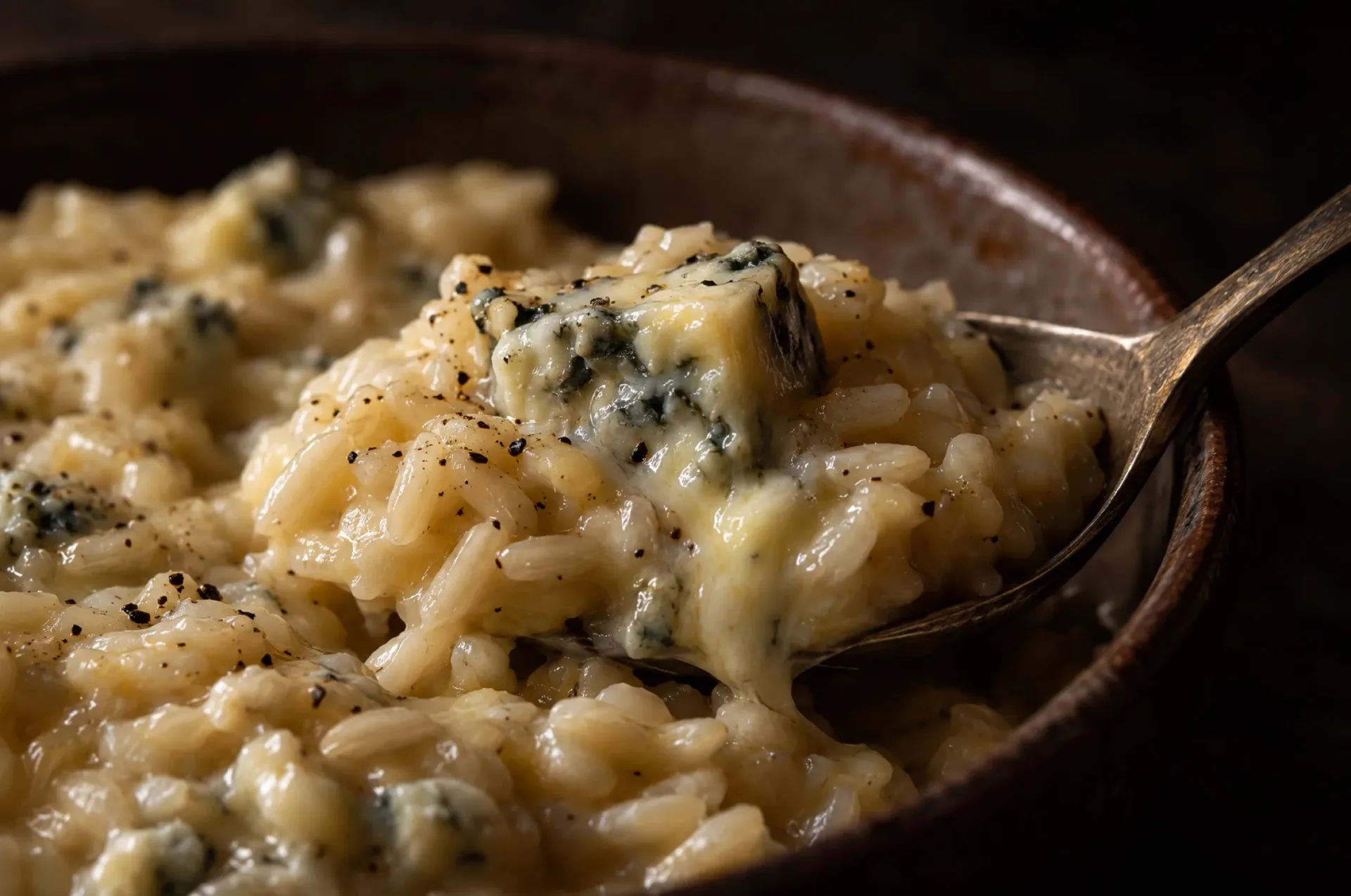 Close-up van risotto ai quattro formaggi met glanzende rijstkorrels en een half gesmolten blokje gorgonzola