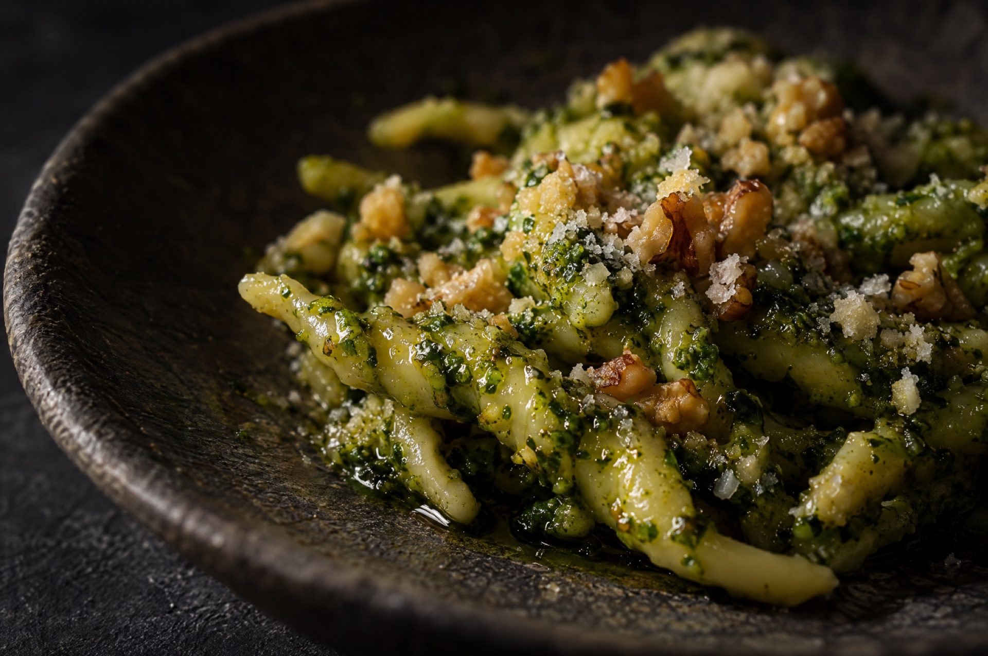 Close-up van selderijpesto met de glans van olijfolie en kruim van walnoot tussen het groene blad